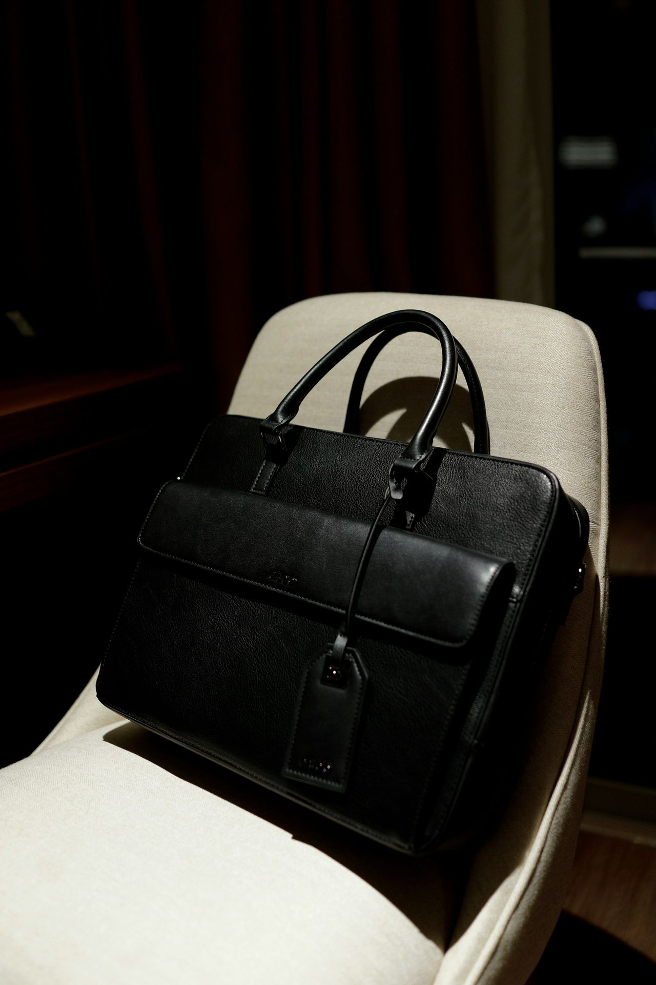 a black bag sitting on top of a white chair